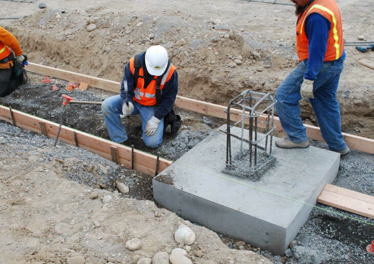 Einzelfundament mit Bauarbeitern